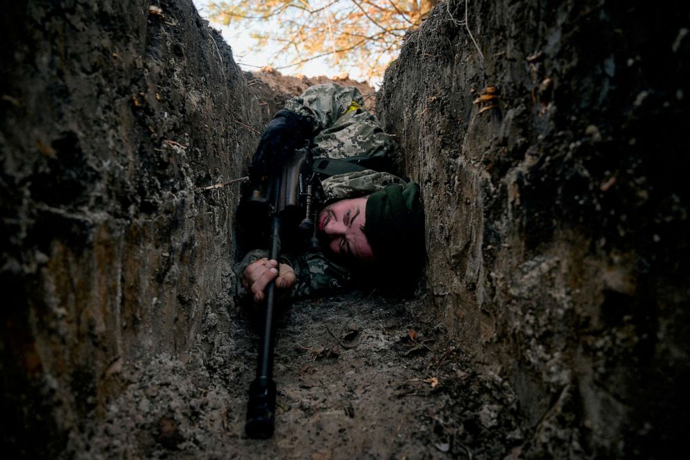 FILE PHOTO: A Ukrainian soldier hides from a helicopter air strike amid Russia's invasion of Ukraine, near Demydiv, Ukraine, March 10, 2022.