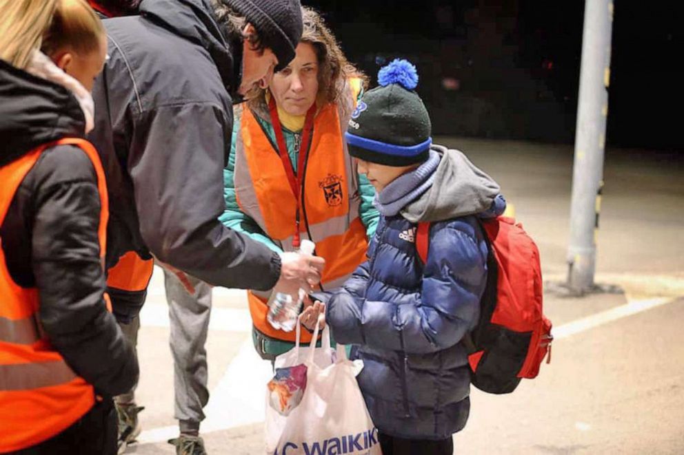 PHOTO: An 11-year-old boy who fled Ukraine by himself is helped by adults after arriving in Slovakia. He was later reunited with his brother in Bratislava.