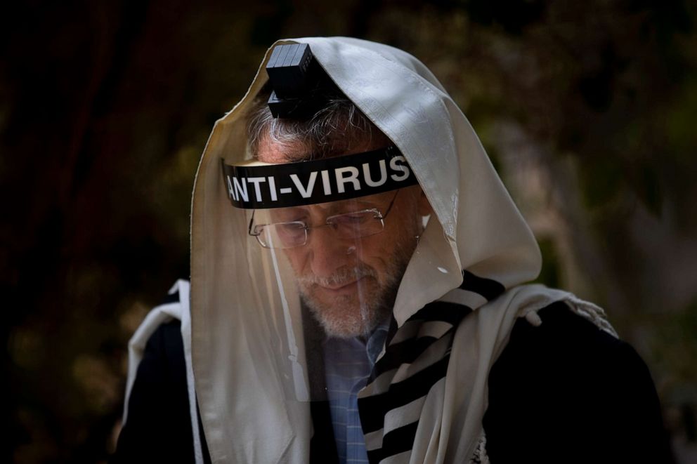 PHOTO: An Ultra-Orthodox Jewish man wears a face shield during morning prayer next to his house in Bnei Brak, Israel, on Sept. 24, 2020, as synagogues are limited to 20 people during a nationwide three-week lockdown to curb the spread of COVID-19.