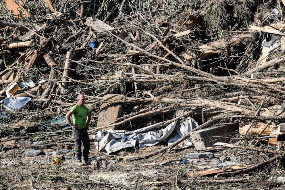PHOTO: In this photograph taken on July 20, 2021, a volunteer with a chainsaw stands in front of uprooted trees in Kreuzberg, Rhineland-Palatinate, western Germany, after devastating floods hit the region.