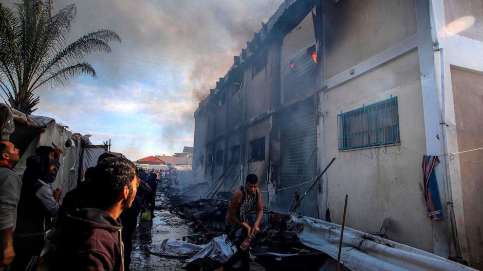 PHOTO: Palestinians try to extinguish a fire at a building of an UNRWA vocational training center which displaced people use as a shelter, after being targeted by Israeli tank shill in Khan Younis, southern Gaza Strip, Jan. 24, 2024.