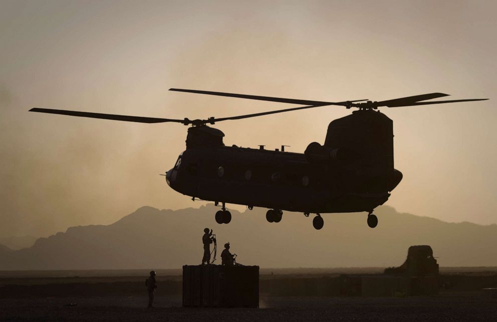 FILE PHOTO: In this file photo taken on June 9, 2011, U.S. Marines direct a Chinook helicopter arriving to pick up a container with supplies at Forward Operating Base E Edinburgh in the Helmand Province of southern Afghanistan.