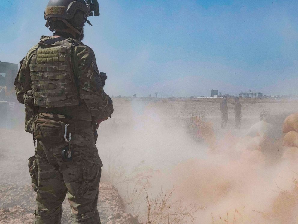 PHOTO: A U.S. service member oversees members of the Syrian Democratic Forces as they demolish a YPG fortification in northeast Syria, Sept. 21, 2019.