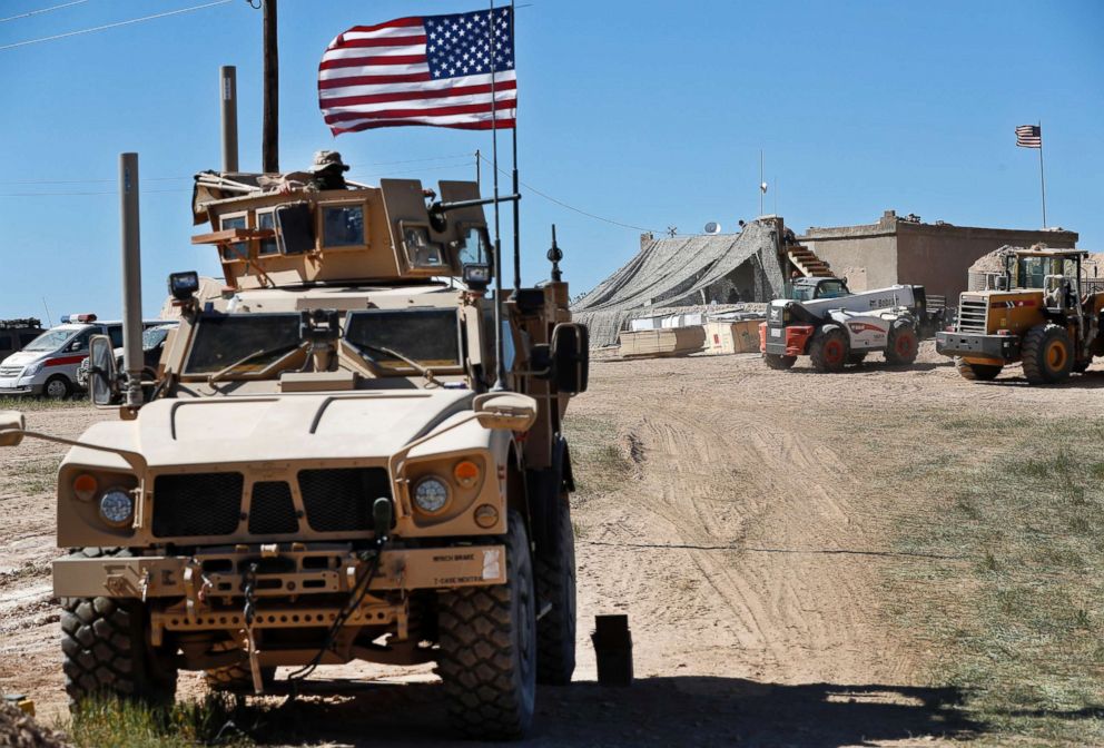 PHOTO: A U.S. soldier sits on an armored vehicle behind a sand barrier at a newly installed position near the front line between the U.S-backed Syrian Manbij Military Council and the Turkish-backed fighters, in Manbij, north Syria.