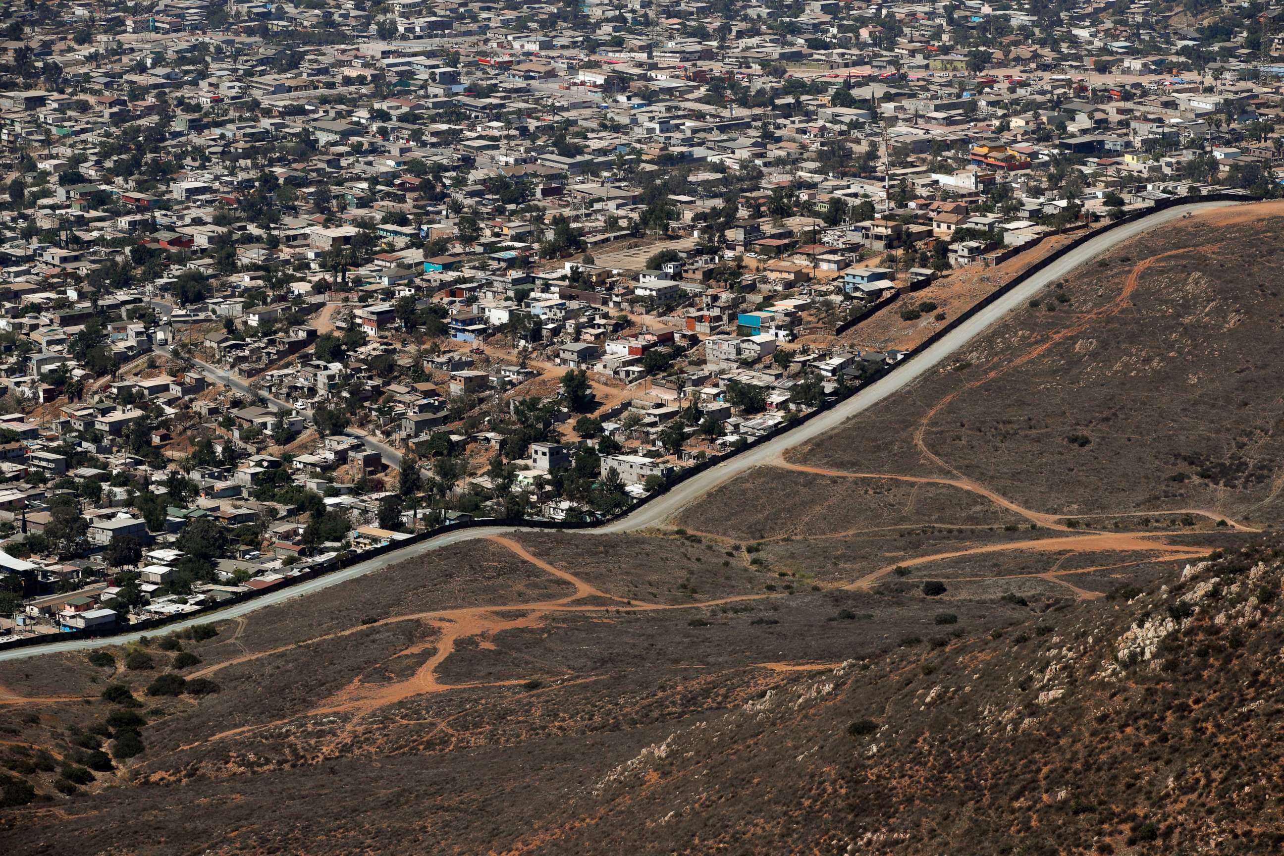 PHOTO: A road runs alongside a border wall that separates Tijuana, Mexico, top, from San Diego, June 28, 2018.