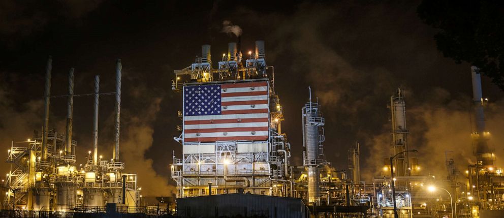 PHOTO: A large American flag is displayed on the side of an oil refinery at night, south of Los Angeles, June 23, 2017.