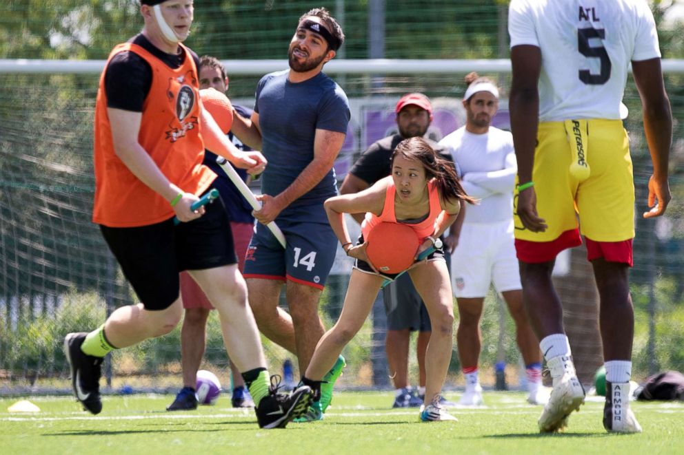 PHOTO: US Quidditch beaters Max Havlin, in blue shirt, and Lulu Xu, in orange, hold "bludgers" (the orange dodgeballs) during practice in Florence, Italy, June 26, 2018.