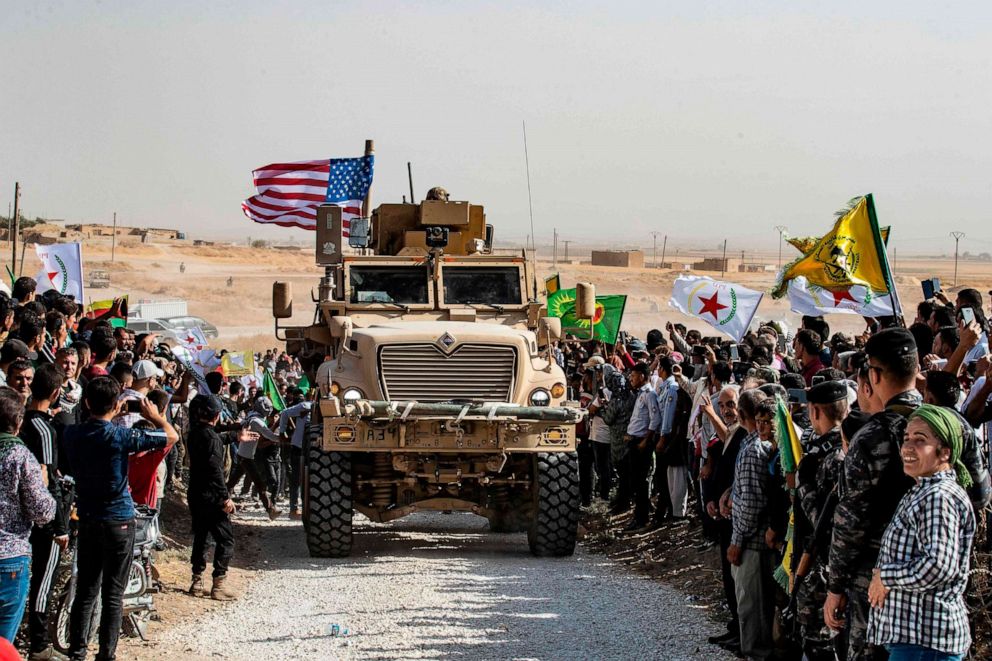 PHOTO: Syrian Kurds gather around a U.S. armored vehicle during a demonstration against Turkish threats next to a US-led international coalition base on the outskirts of Ras al-Ain town in Syria's Hasakeh province near the Turkish border, Oct. 6, 2019.