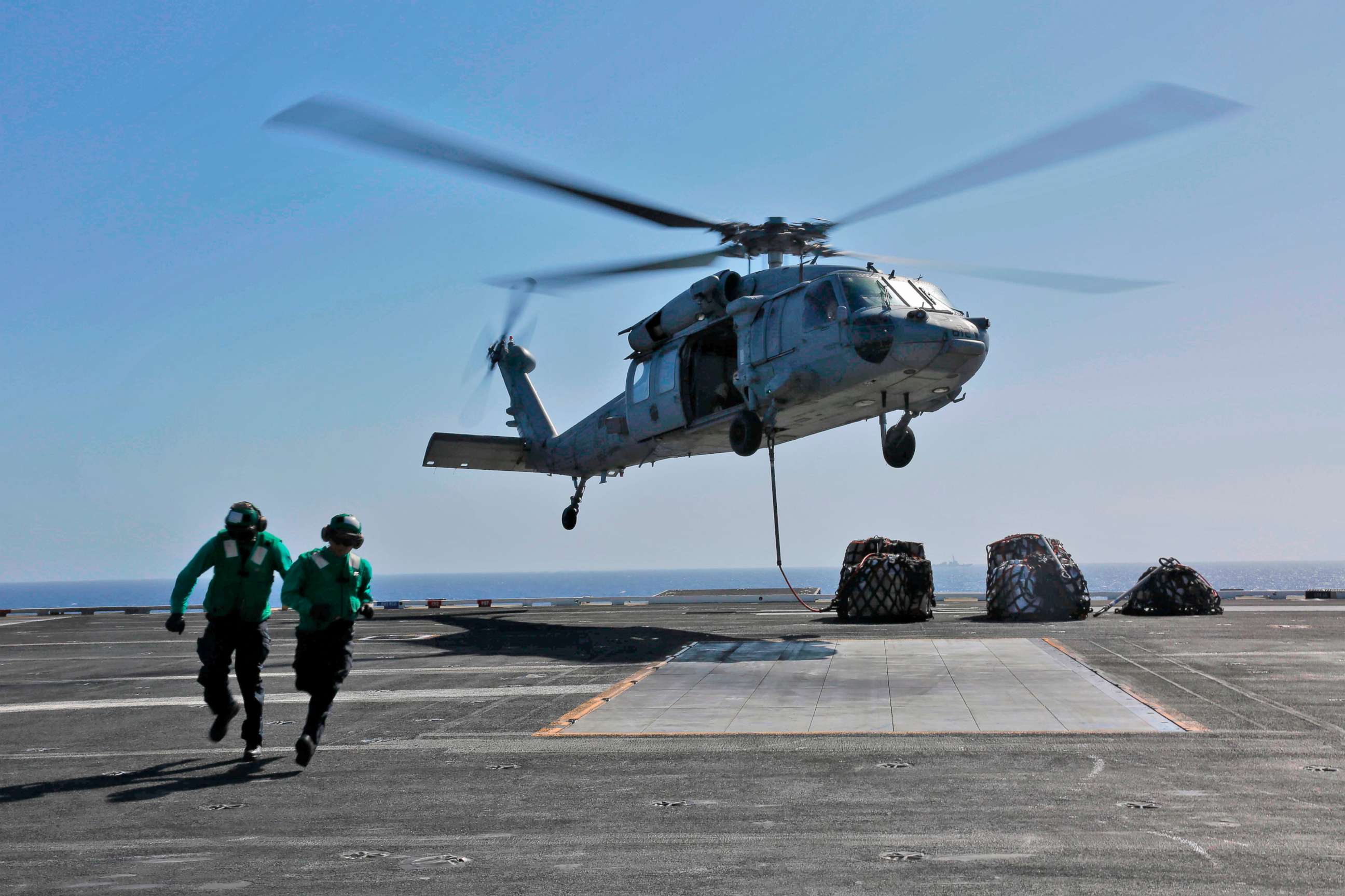 This image released,May 10, 2019 shows a naval logistics specialists attaches cargo to an MH-60S Sea Hawk helicopter from the "Nightdippers" of Helicopter Sea Combat Squadron 5 from the flight deck of the Nimitz-class aircraft carrier USS Abraham Lincoln.