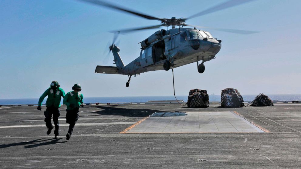 This image released,May 10, 2019 shows a naval logistics specialists attaches cargo to an MH-60S Sea Hawk helicopter from the "Nightdippers" of Helicopter Sea Combat Squadron 5 from the flight deck of the Nimitz-class aircraft carrier USS Abraham Lincoln.