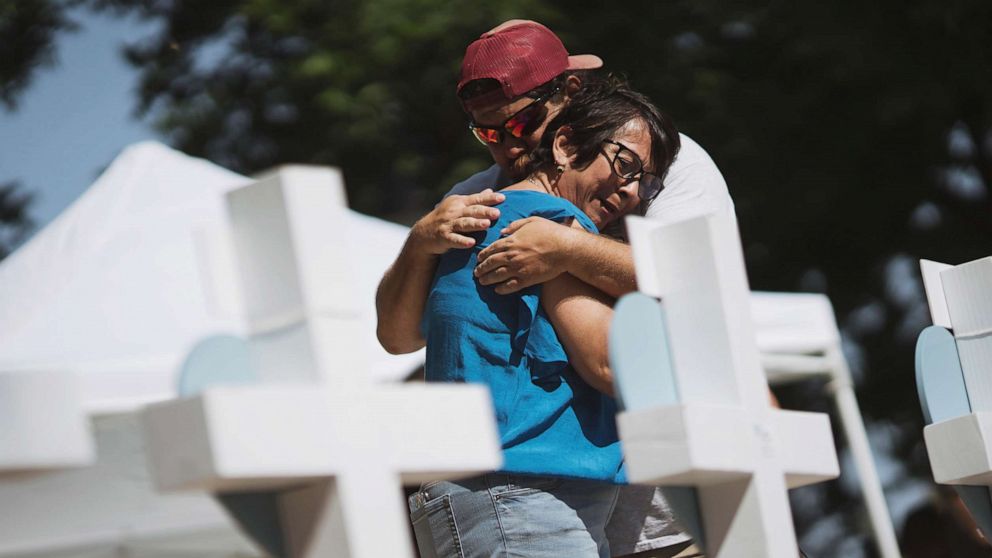 PHOTO: People embrace at a memorial in the town square for victims of Tuesday's mass shooting at Robb Elementary School on May 26, 2022 in Uvalde, Texas.