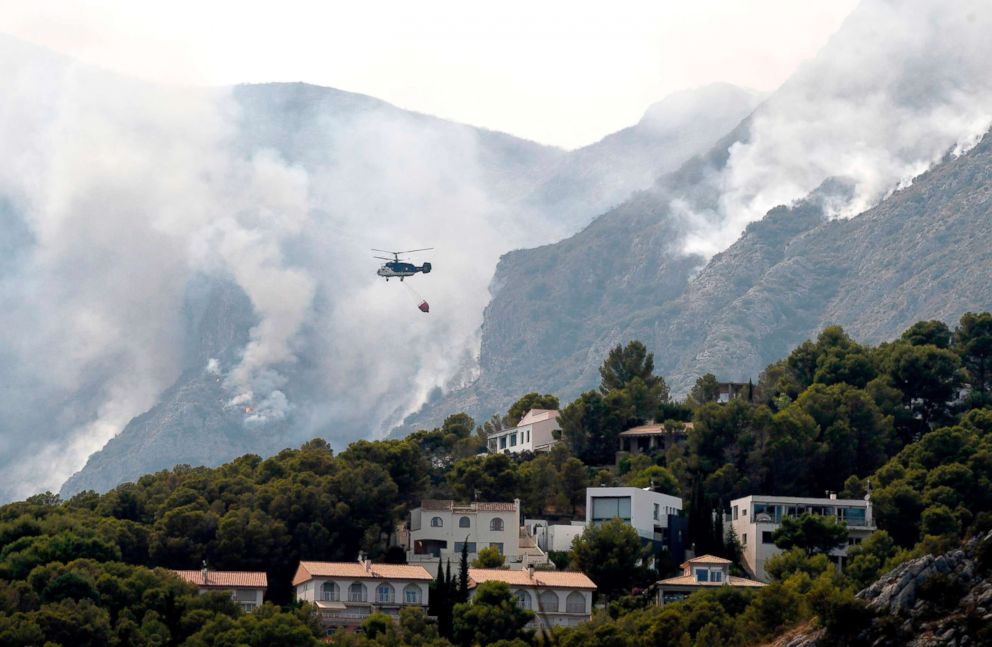 PHOTO: A helicopter drops water over a wildfire in Pinet, in the eastern Spanish region of Valencia, August 7, 2018.