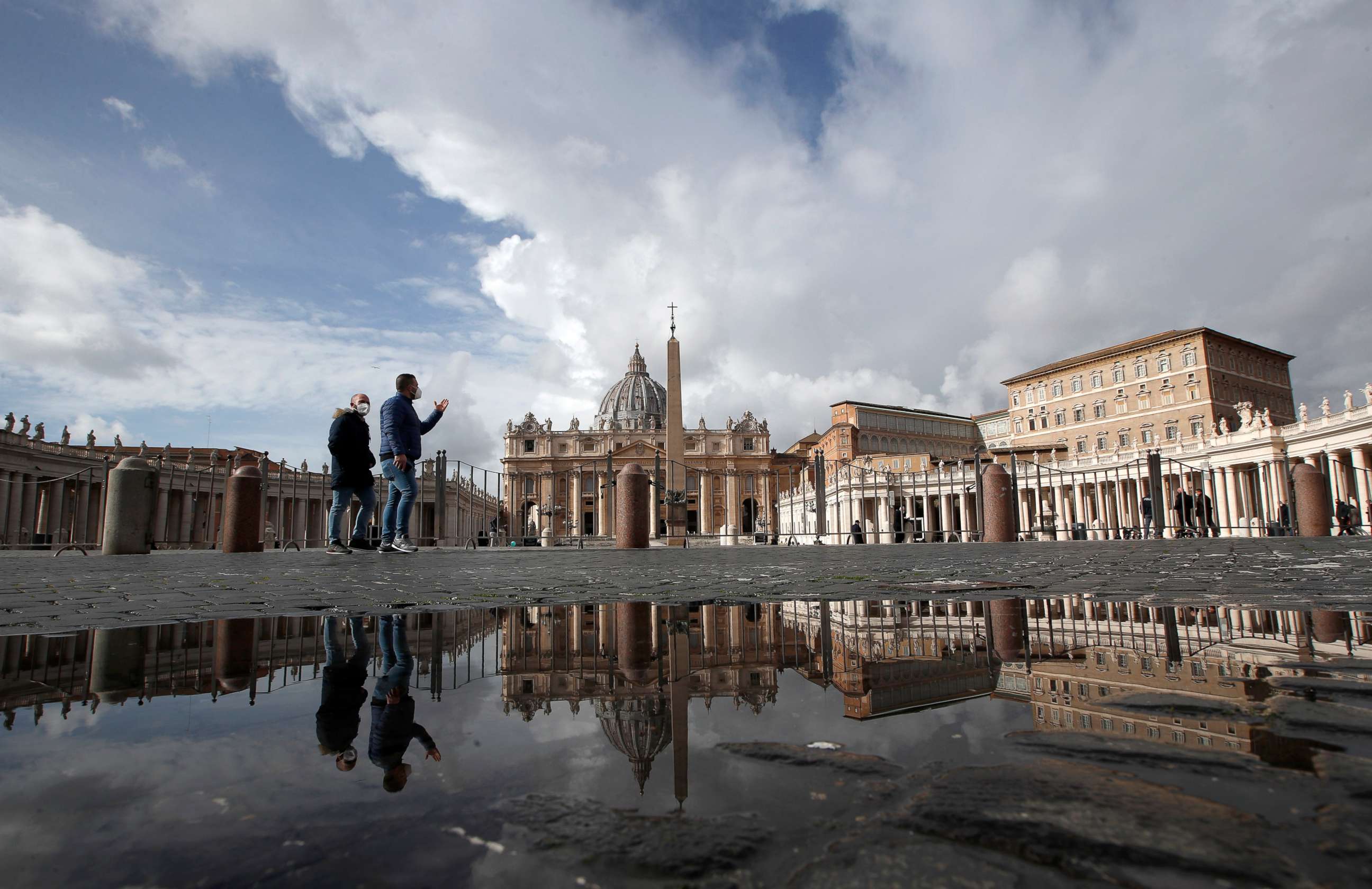 PHOTO: \In this Sunday, Jan. 31, 2021 file photo, people are reflected on a puddle as they walk in St. Peter's Square, at the Vatican.