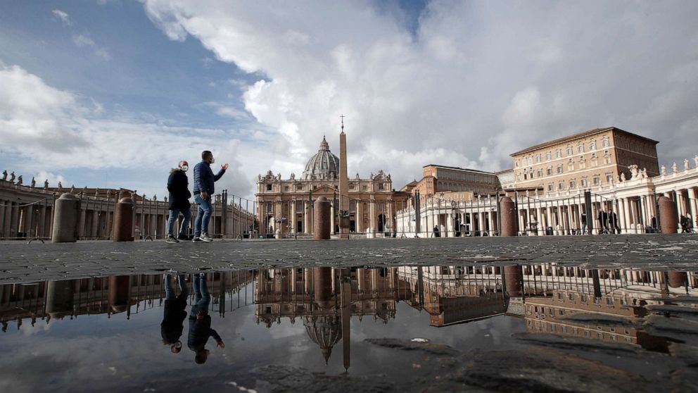 PHOTO: \In this Sunday, Jan. 31, 2021 file photo, people are reflected on a puddle as they walk in St. Peter's Square, at the Vatican.
