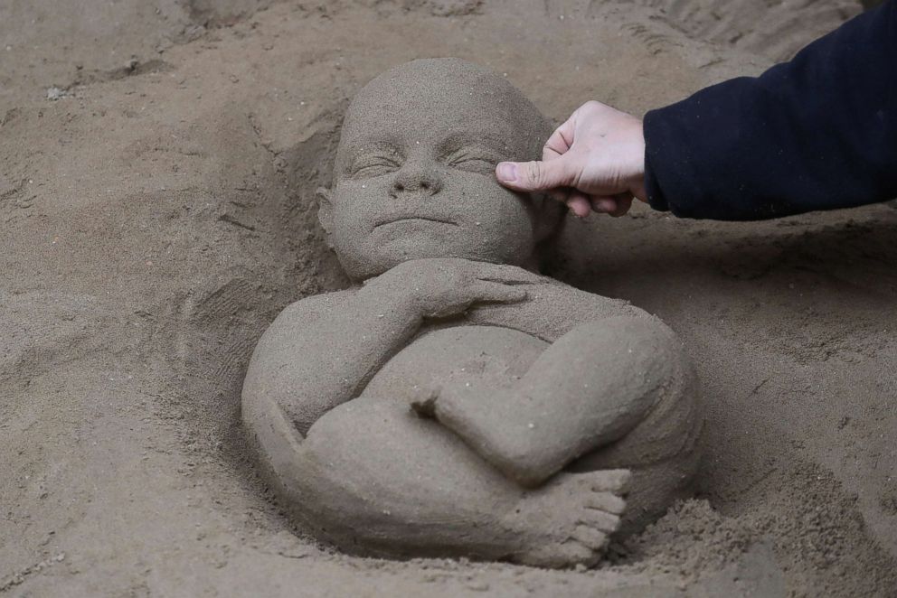 PHOTO: An artist works on a sand sculpture representing baby Jesus as a part of nativity scene in St. Peter's square at the Vatican, Dec. 6, 2018.