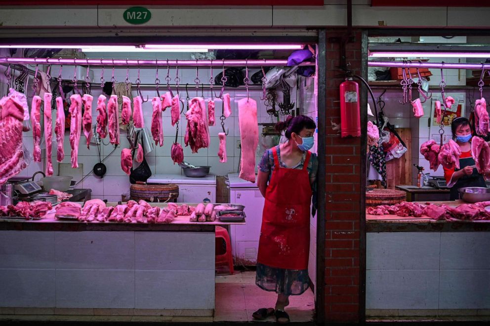 PHOTO: Vendors wearing face masks wait for customers in a market in Wuhan in China's central Hubei province on May 18, 2020.