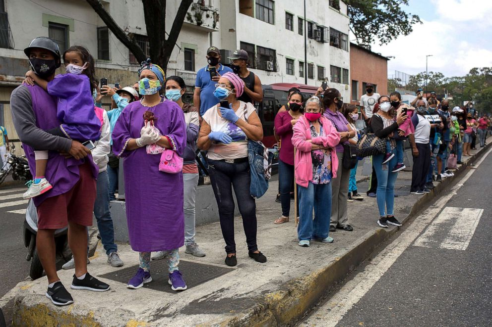 PHOTO: Catholic faithful wearing face masks as they watch the religious procession during Holy Week celebrations in Caracas, Venezuela, March 31, 2021. 