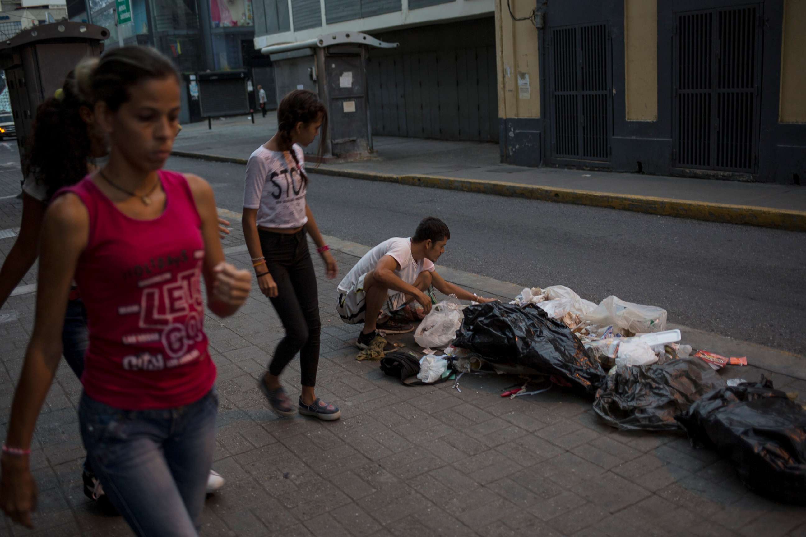 PHOTO: Kevin Gonzalez searches for food in the trash, on a sidewalk in Caracas, Venezuela, July 16, 2019. 