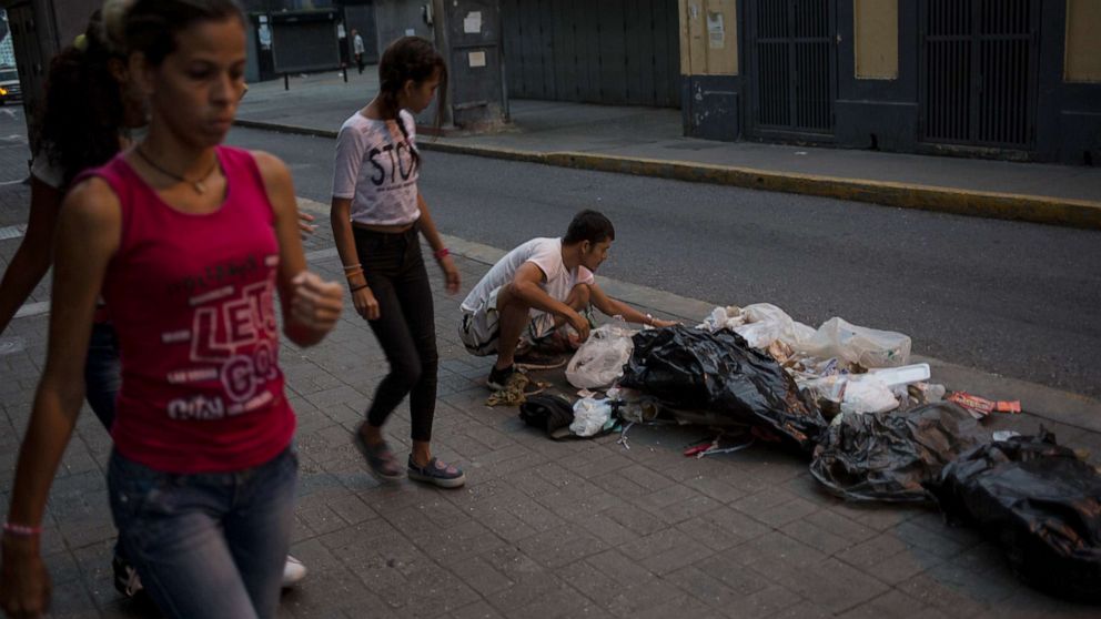 PHOTO: Kevin Gonzalez searches for food in the trash, on a sidewalk in Caracas, Venezuela, July 16, 2019.