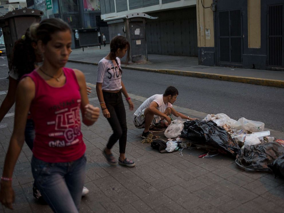 PHOTO: Kevin Gonzalez searches for food in the trash, on a sidewalk in Caracas, Venezuela, July 16, 2019.