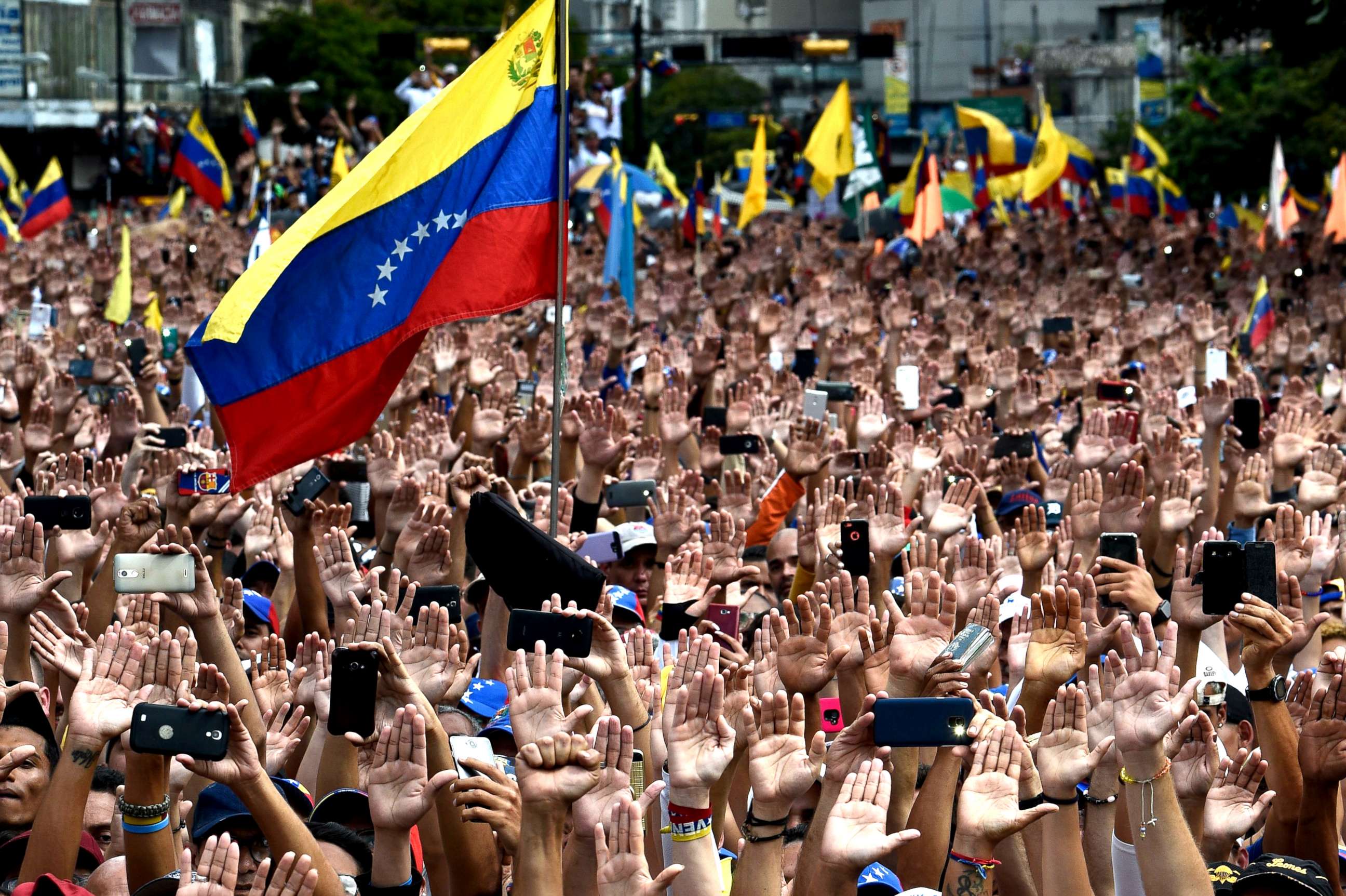 PHOTO: People raise their hands during a mass opposition rally against President Nicolas Maduro in in Caracas, Venezuela, Jan. 23, 2019. 