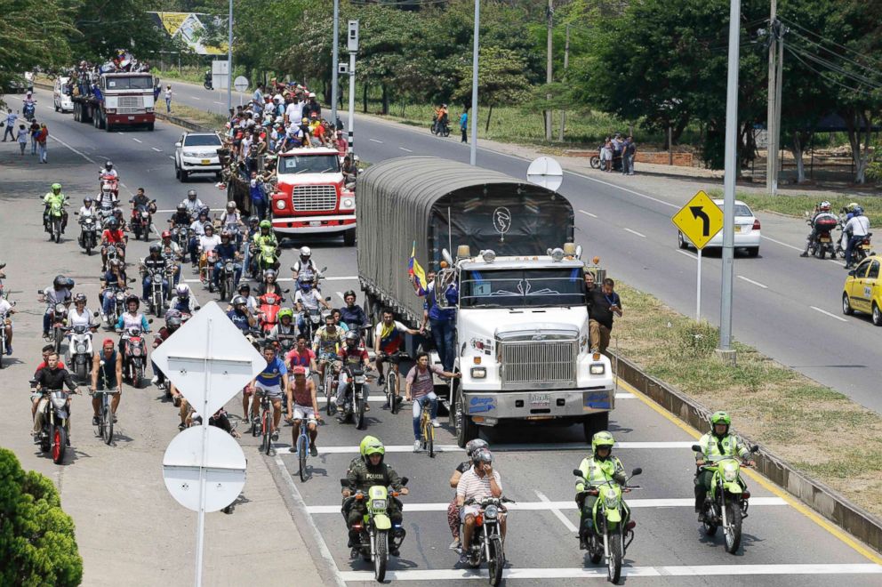 PHOTO: Venezuelans ride atop and alongside semi-trailers accompanying U.S. humanitarian aid destined for Venezuela, in Cucuta, Colombia, Feb. 23, 2019.