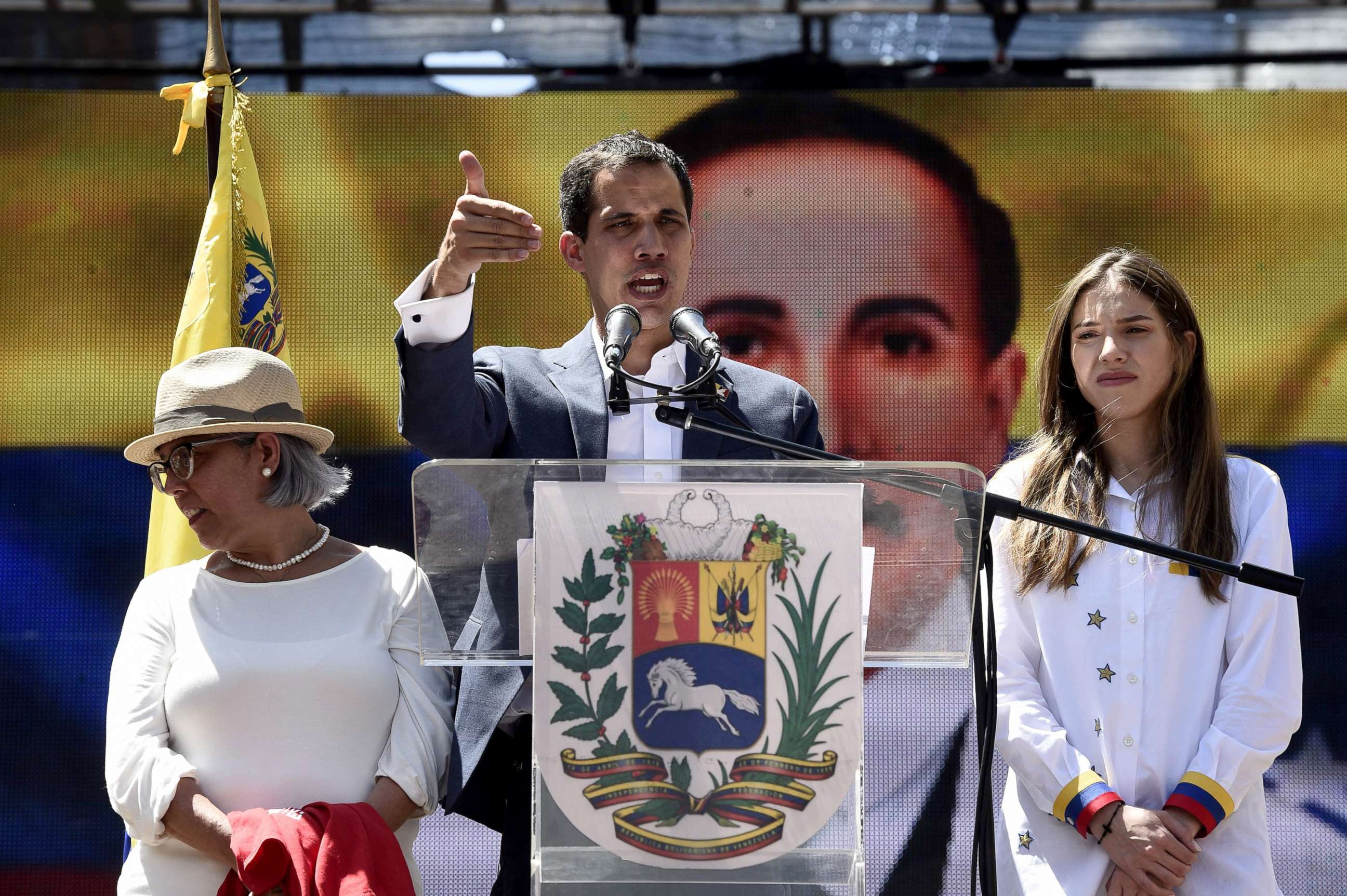 PHOTO: Venezuelan opposition leader and self declared acting president Juan Guaido, accompanied by his mother Norka Marquez, left, and wife Fabiana Rosales, speaks to supporters during a rally in Caracas, Feb. 12, 2019.