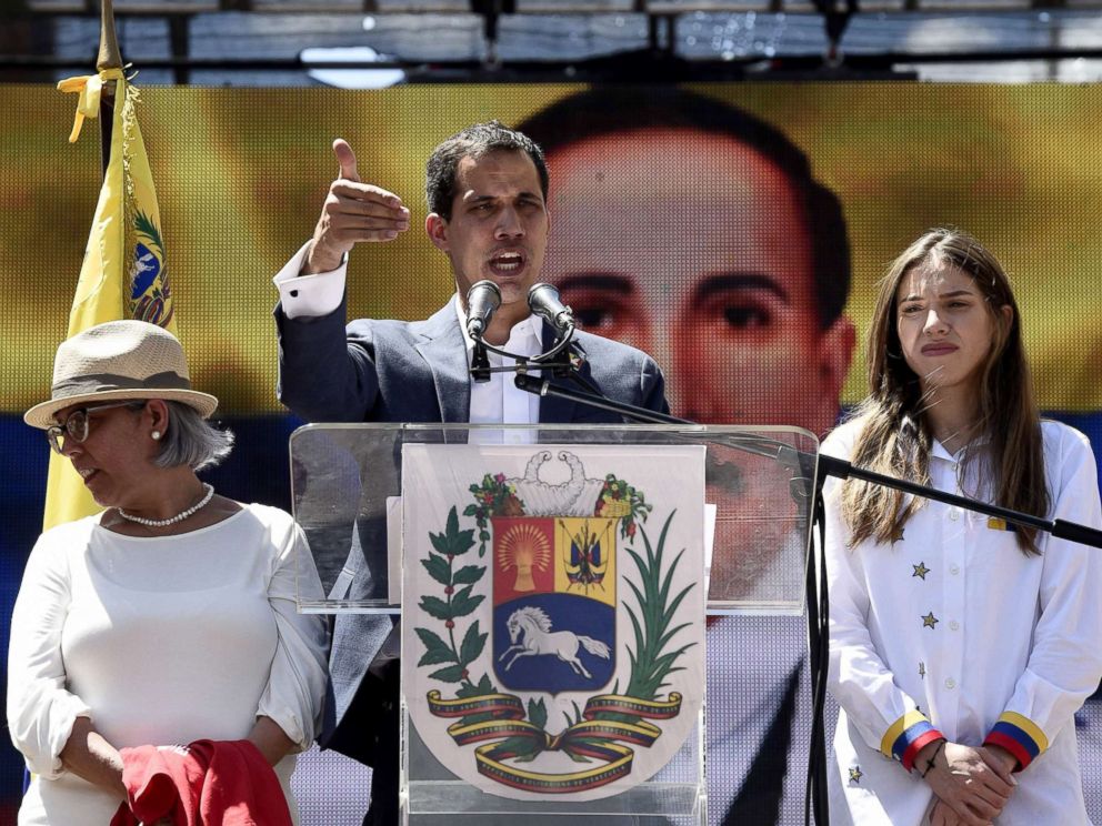PHOTO: Venezuelan opposition leader and self declared acting president Juan Guaido, accompanied by his mother Norka Marquez, left, and wife Fabiana Rosales, speaks to supporters during a rally in Caracas, Feb. 12, 2019.