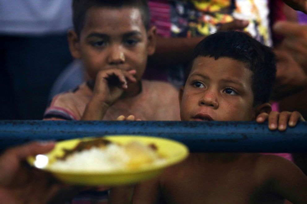 PHOTO: Venezuelan children wait for a free meal at a migrant shelter set up at the Tancredo Neves Gymnasium in Boa Vista, Roraima state, Brazil.