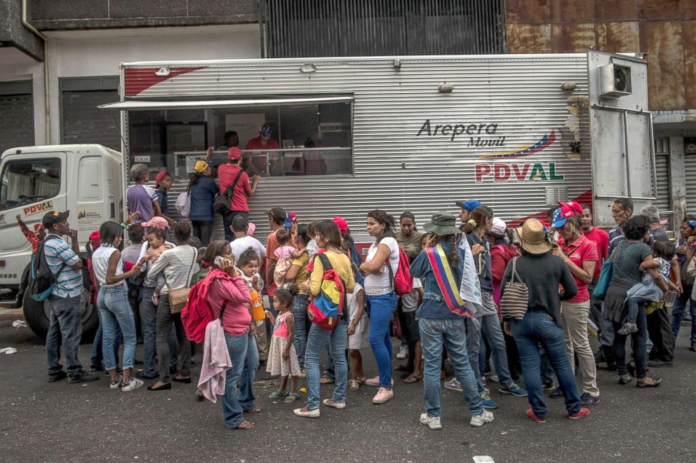 PHOTO: Government supporters line up to buy government subsidized arepas and juice, after a rally for President Nicolas Maduro in Caracas, Venezuela, May 1, 2018.