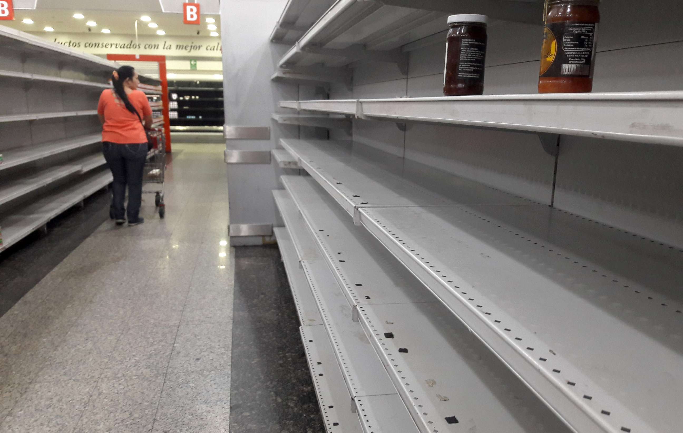 PHOTO: A woman walks between the empty shelves of a supermarket in Caracas, Venezuela, Jan. 11, 2018.