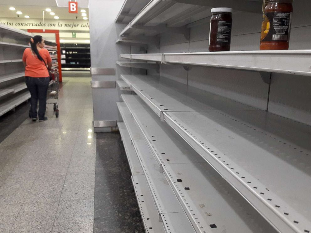 PHOTO: A woman walks between the empty shelves of a supermarket in Caracas, Venezuela, Jan. 11, 2018.