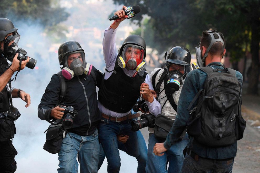 PHOTO: Venezuelan journalist Gregory Jaimes, center, is assisted by colleagues after being injured during clashes between anti-government protesters and security forces during the commemoration of May Day on May 1, 2019.