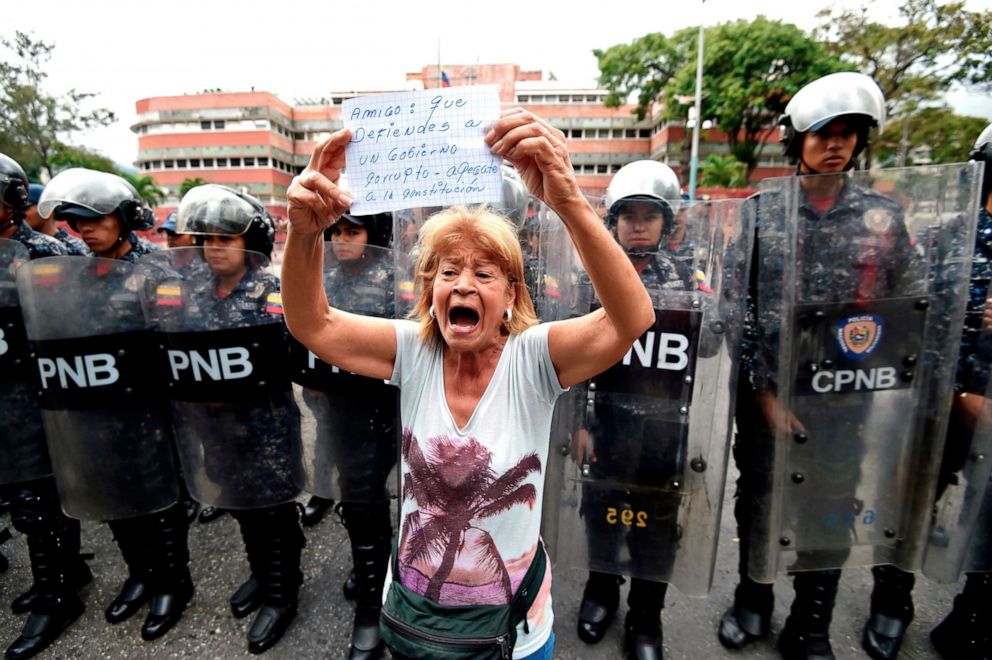 PHOTO: A woman demonstrates with a sign reading "Friend: you who defend a corrupt government, get attached to the constitution," outside the Venezuelan Navy command headquarters at San Bernardino neighborhood in Caracas, Venezuela, May 4, 2019.