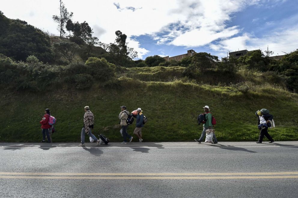 PHOTO: Members of Venezuelan families Mendoza Landinez and Lomelly, walk along the Pan-American Highway in Colombia on their way to Peru, Aug. 23, 2018.