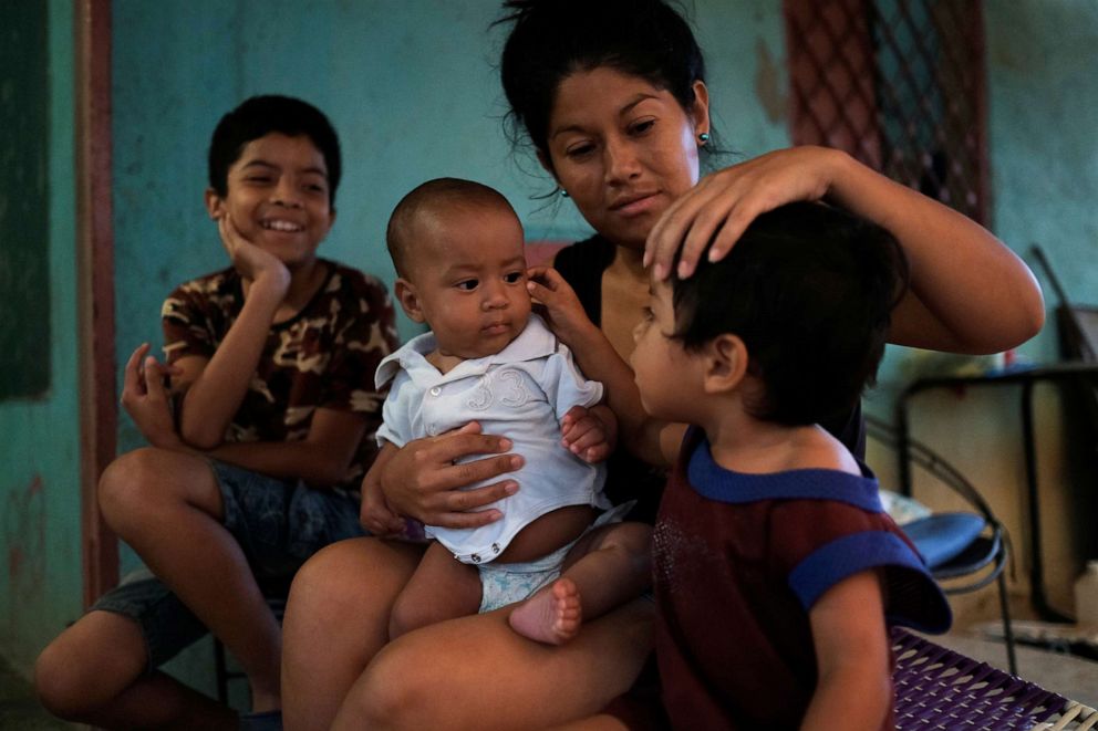 PHOTO: Francys Rivero holds her five-month-old son Kenai, who recovered from malnutrition, while talking to her sons Collins, 11, and Enmanuel, 2, outside their home in Barquisimeto, Venezuela, Nov. 27, 2019.