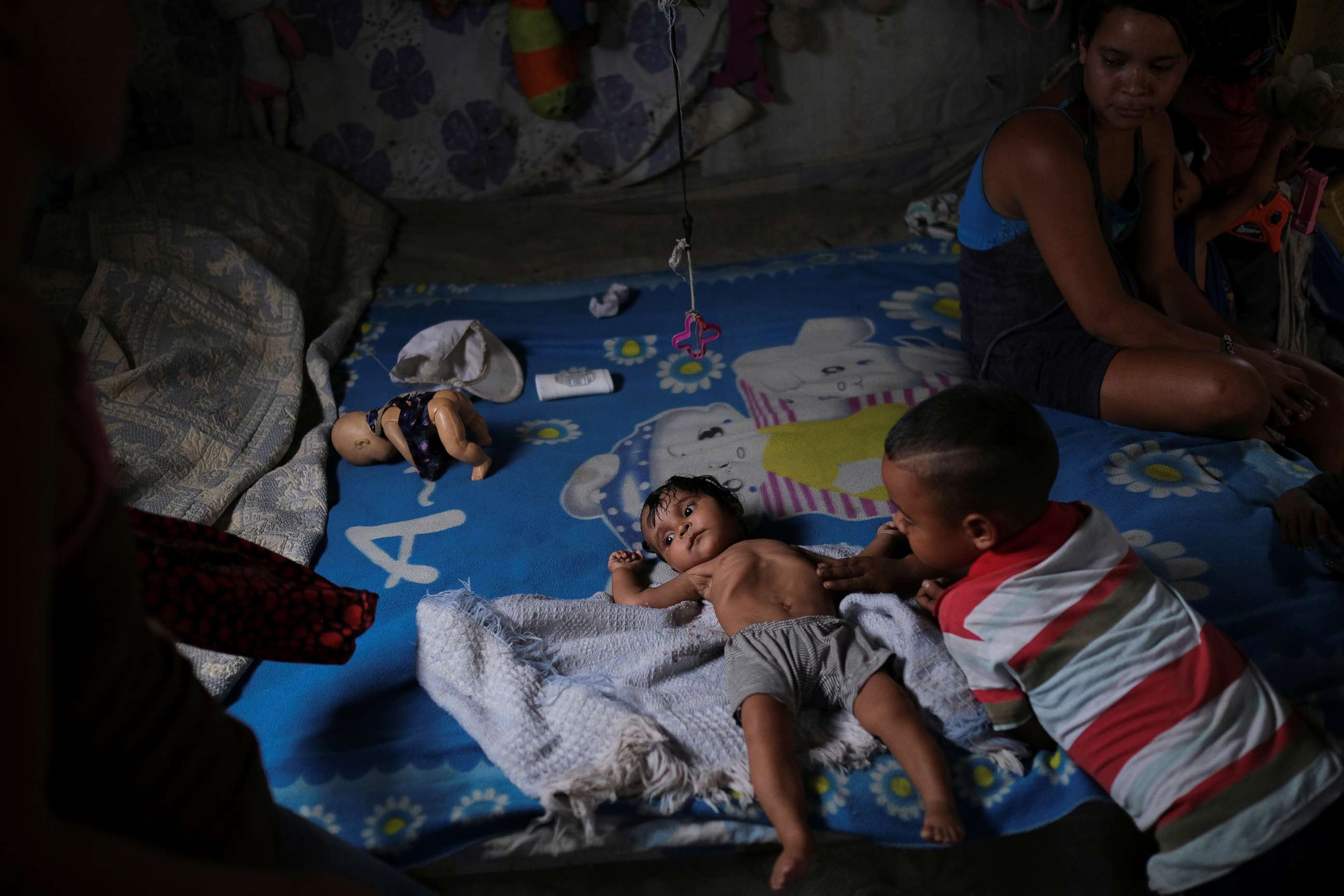 PHOTO: Gregoria Hernandez, 23, sits next to her seven-moth-old daughter Sonia, who according to her has diarrhoea and is underweight, while resting on a bed in Barquisimeto, Venezuela, Aug. 16, 2019.