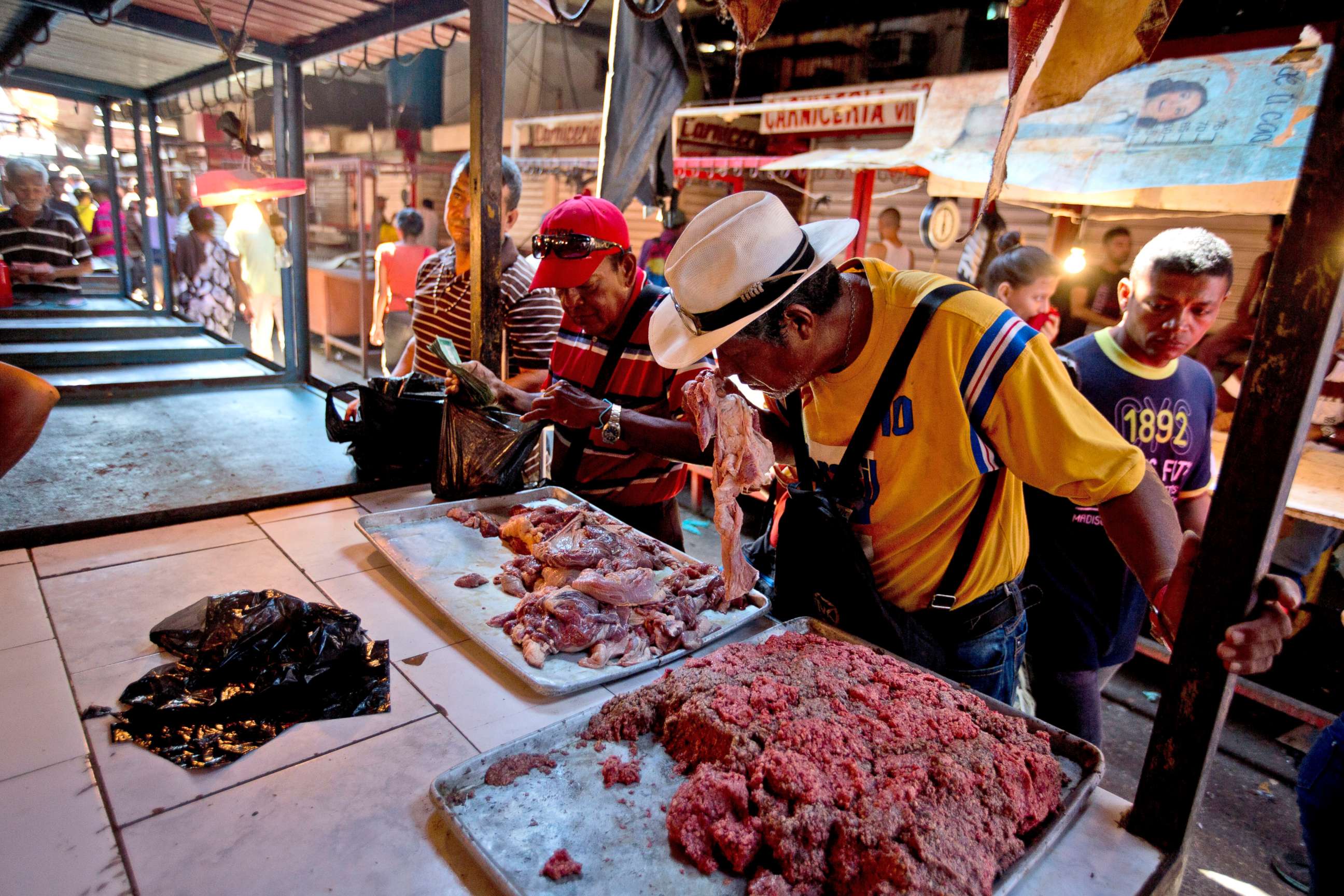PHOTO: A customer smells a piece of spoiled meat at a market in Maracaibo, Venezuela, Aug. 19, 2018.