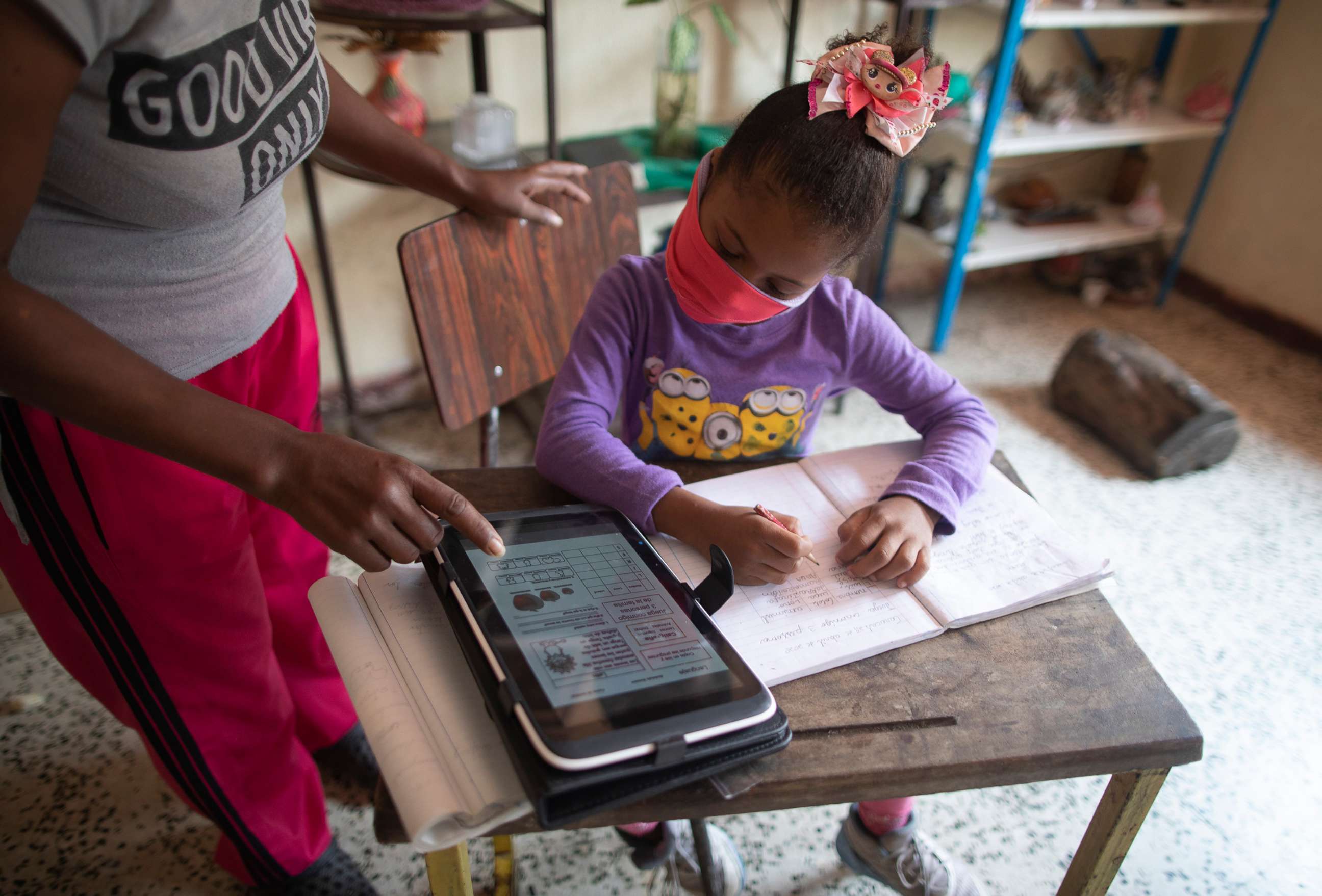 PHOTO: Yolanda Avila watches over her niece Sofia, a first grader, who does her homework using a tablet at their home in Caracas, Venezuela, on April 29, 2020.