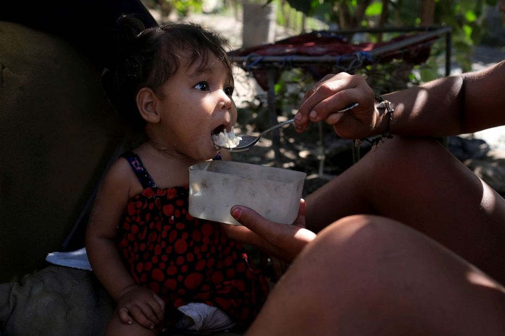 PHOTO: Gregoria Hernandez feeds pasta and rice for lunch to her daughter Sonia, who was hospitalised a couple of months ago for malnutrition, at their house in Barquisimeto, Venezuela, Nov. 28, 2019.