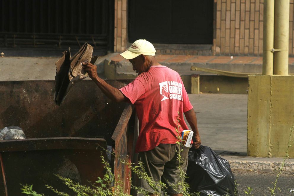 PHOTO: A man checks the trash to get food to eat in San Francisco,Venezuela, June 7, 2018.