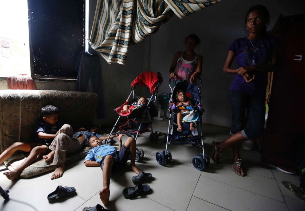 PHOTO: Venezuelan children are watched over by a few of their mothers while others work, inside a sparsely furnished home shared by about 10 people in Cucuta, Colombia, June 27, 2018.