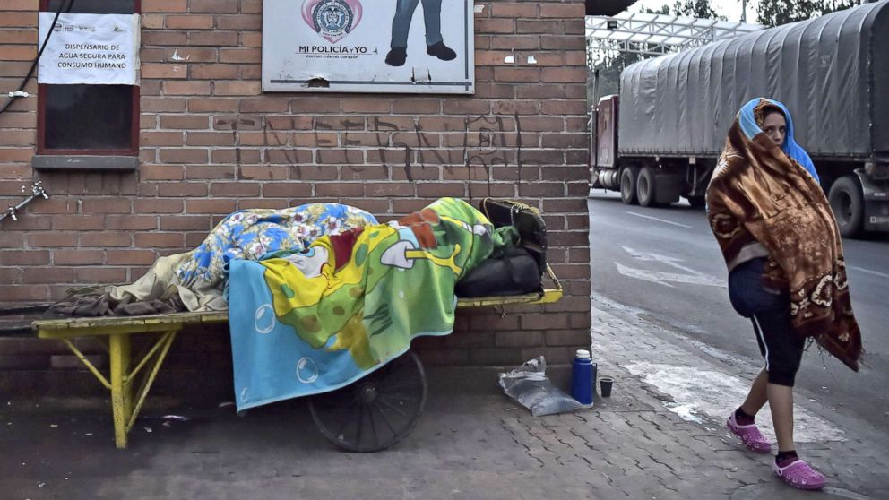 PHOTO: A Venezuelan citizen rests as another one walks at the Rumichaca international bridge in Tulcan, Ecuador, in the border with Colombia, Aug. 11, 2018.