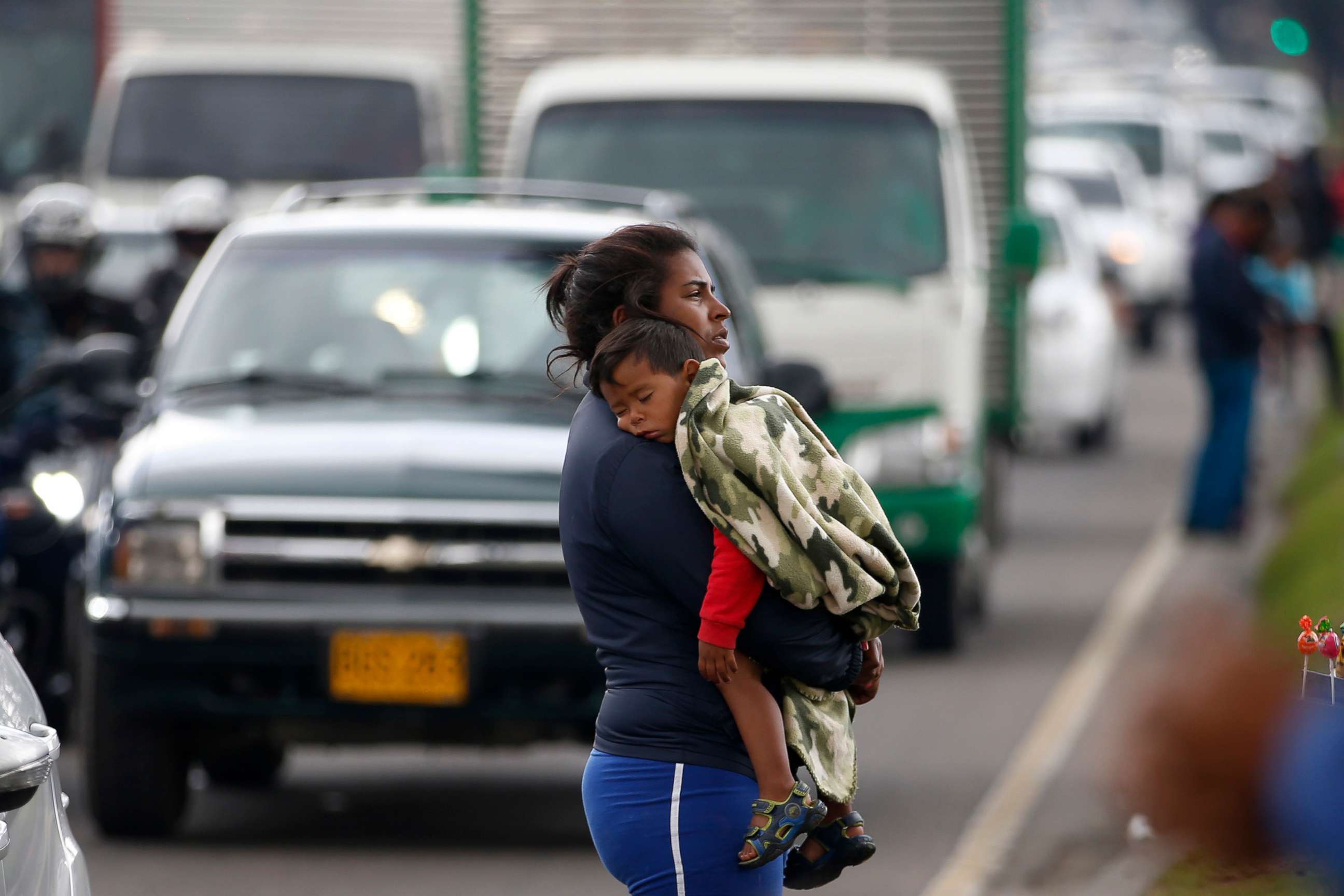 PHOTO: A Venezuelan migrant waits for traffic to come to a standstill so that she can ask drivers for spare change, in Bogota, April 4, 2019.