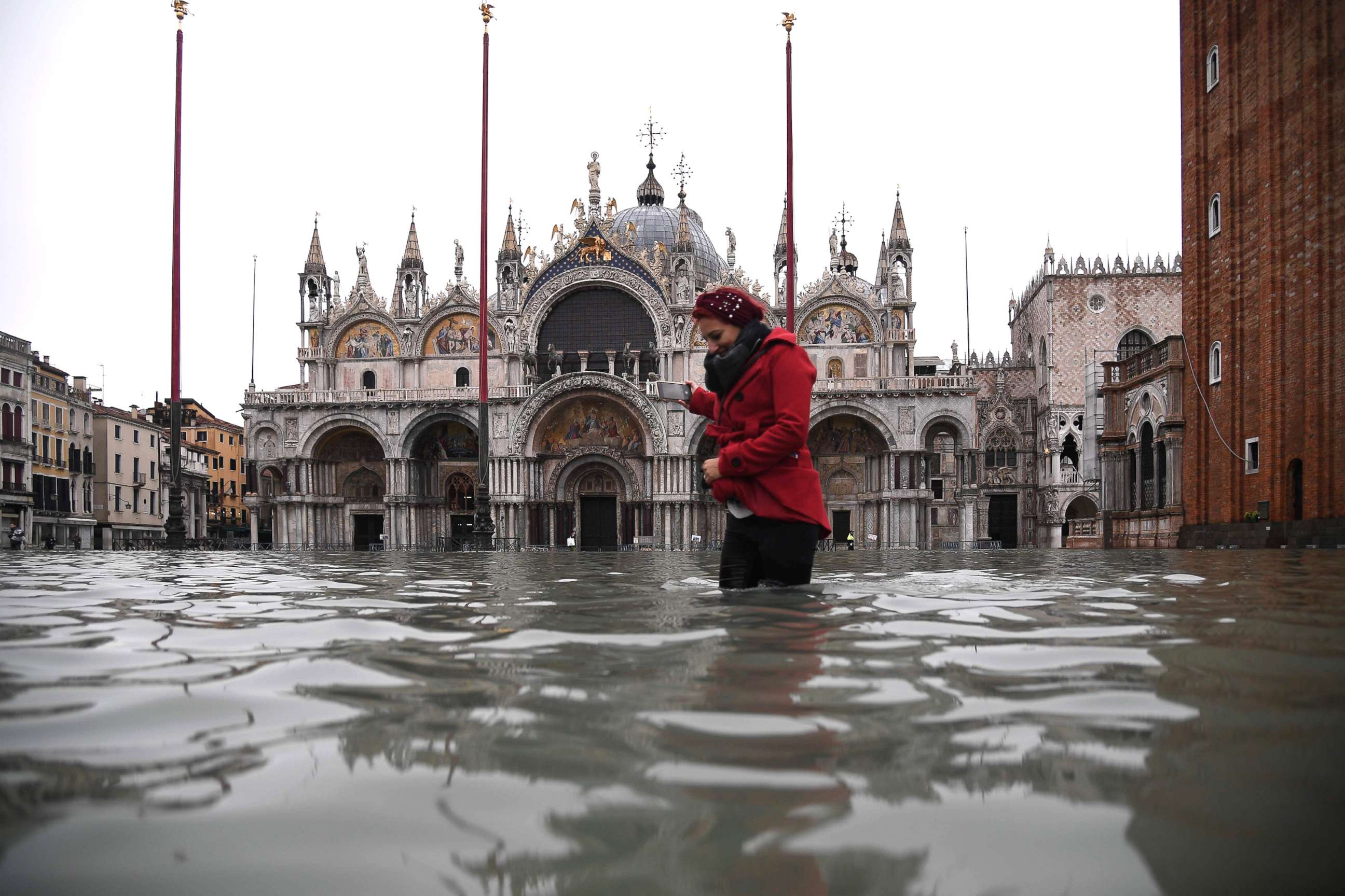 PHOTO: A woman  crosses the flooded St. Mark's square by St. Mark's Basilica after an exceptional overnight "Alta Acqua" high tide water level, Nov. 13, 2019 in Venice. 
