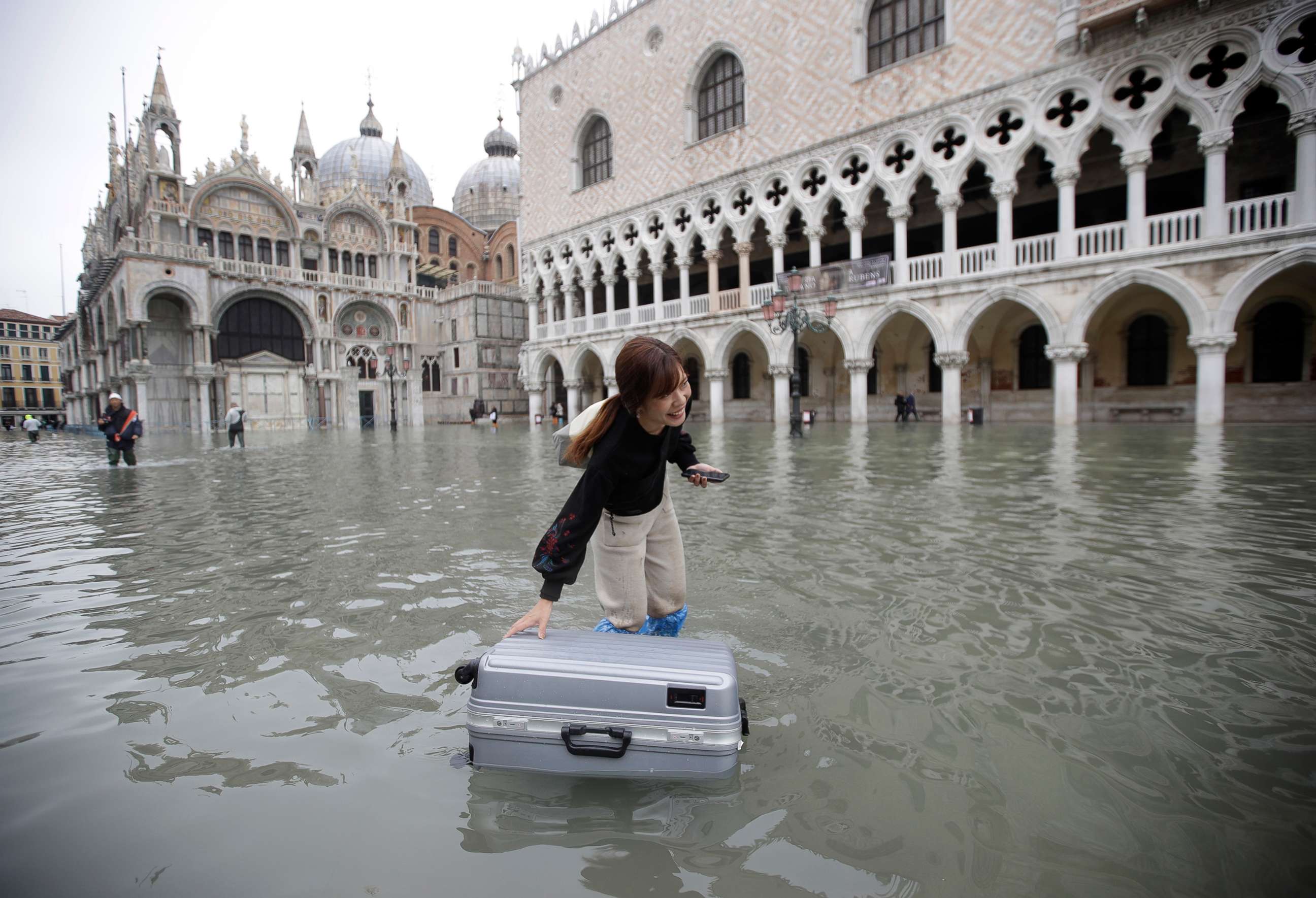 PHOTO: A tourist pushes her floating luggage in a flooded St. Mark's Square, in Venice, Nov. 13, 2019.