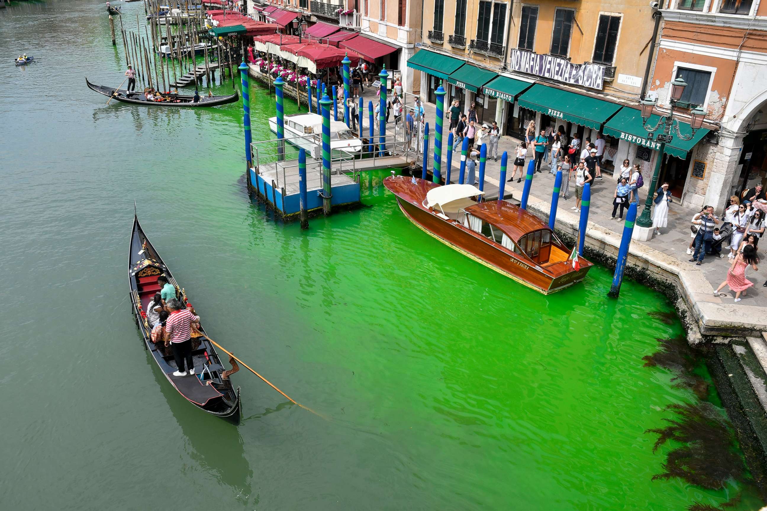 PHOTO: A gondola navigates along Venice's historical Grand Canal as a patch of phosphorescent green liquid spreads in it, May 28, 2023, in Venice, Italy.