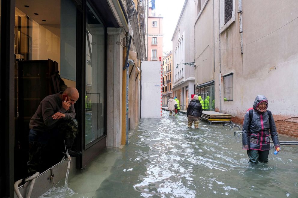 PHOTO: People walk in the flooded street during a period of seasonal high water in Venice, Italy, Nov. 15, 2019.