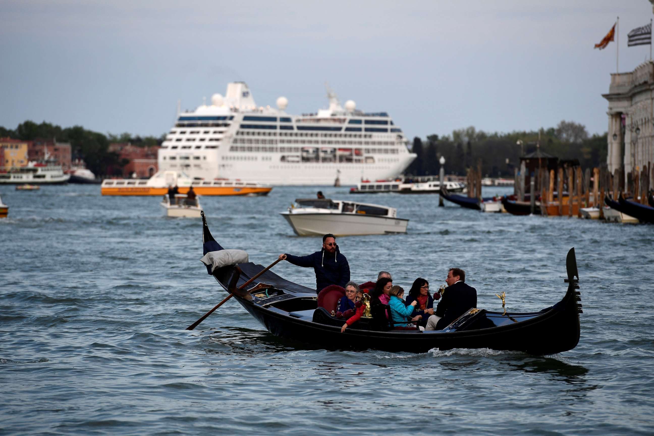 PHOTO: A cruise ship sits in the distance as a gondola with tourists navigates the Grand Canal in Venice on April 7, 2017.