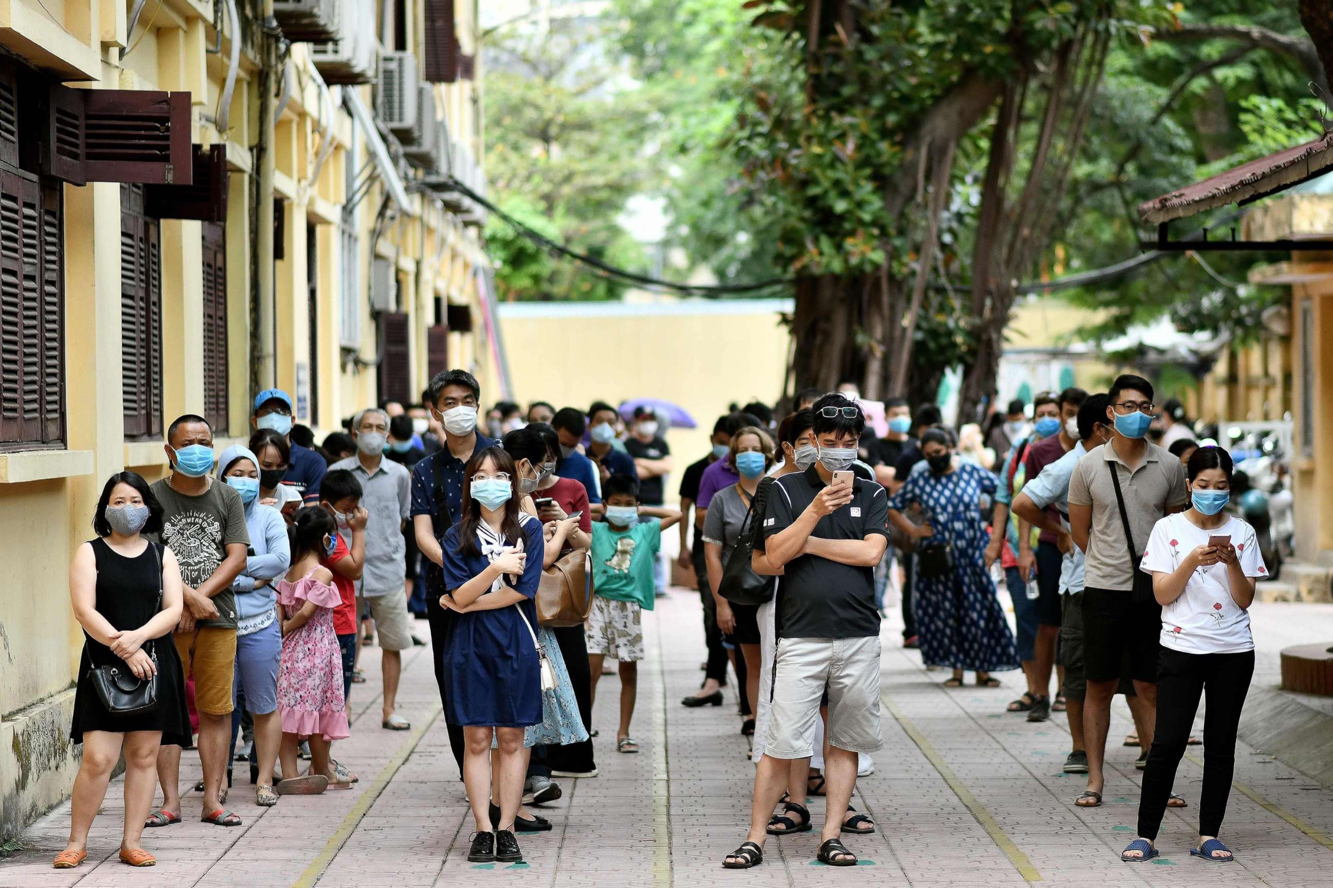 PHOTO: People observe social distancing while waiting to be tested at a makeshift rapid testing centre in Hanoi on Aug. 1, 2020, as Vietnam records a rise in cases of COVID-19.